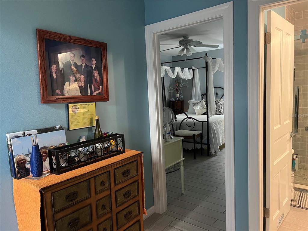 4154 66th St Circle West, Unit 4154 Bradenton, FL 34209 - Photo 20 of 28 a hallway with a couch and a dining table next to a window