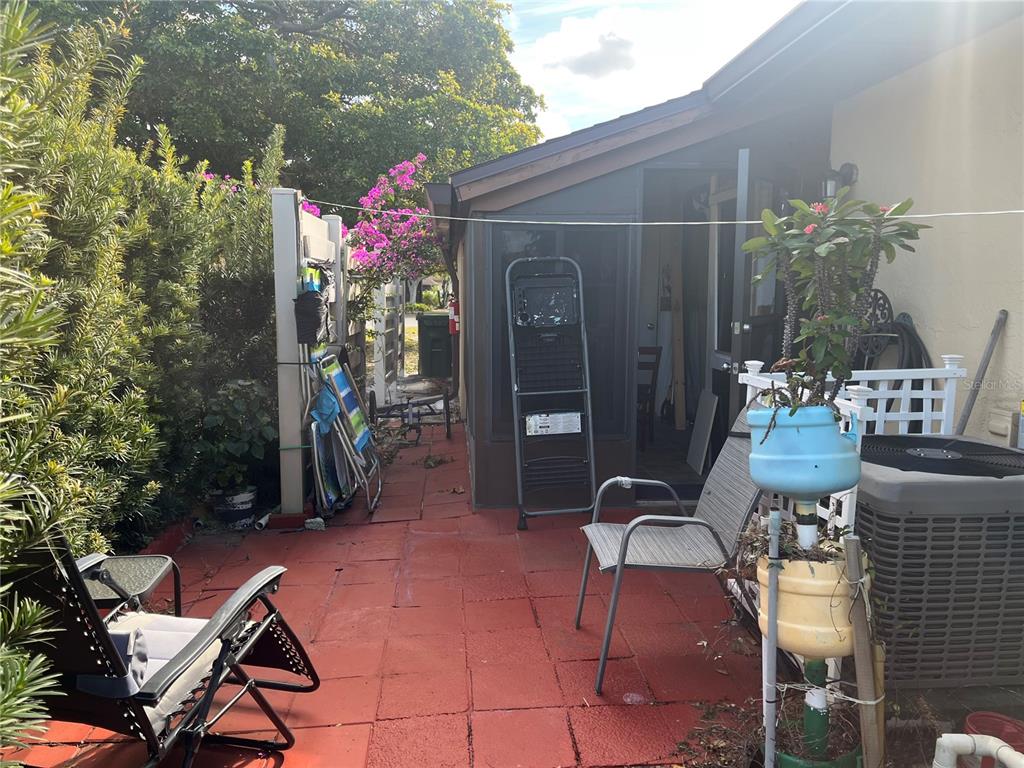 4154 66th St Circle West, Unit 4154 Bradenton, FL 34209 - Photo 24 of 28 a patio with table and chairs and potted plants