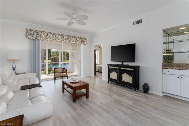 a living room with furniture and a flat screen tv with wooden floor