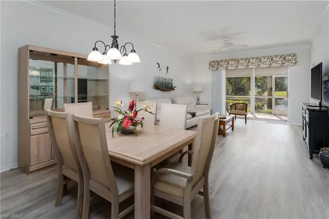 a view of a dining room with furniture a chandelier and wooden floor