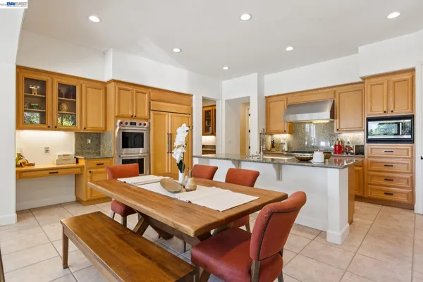 a large kitchen with kitchen island granite countertop a large dining table and chairs