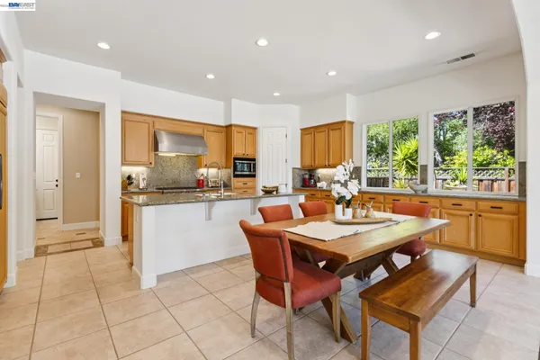 a dining room with a table chairs and a kitchen view