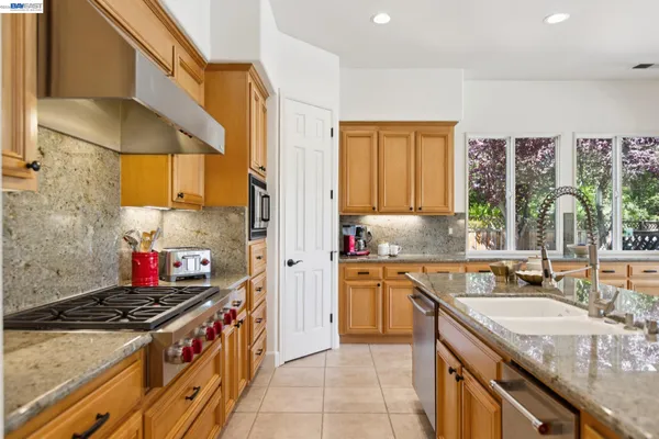 a kitchen with stainless steel appliances granite countertop a sink stove and refrigerator