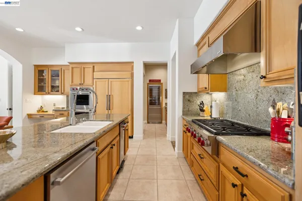 a kitchen with stainless steel appliances granite countertop a sink stove and refrigerator