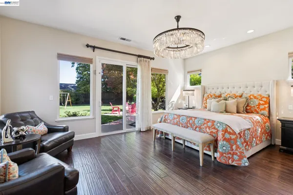 a bedroom with a bed a flat tv screen and a window