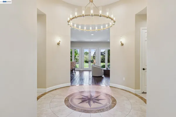 a view of a hallway with dining room and chandelier