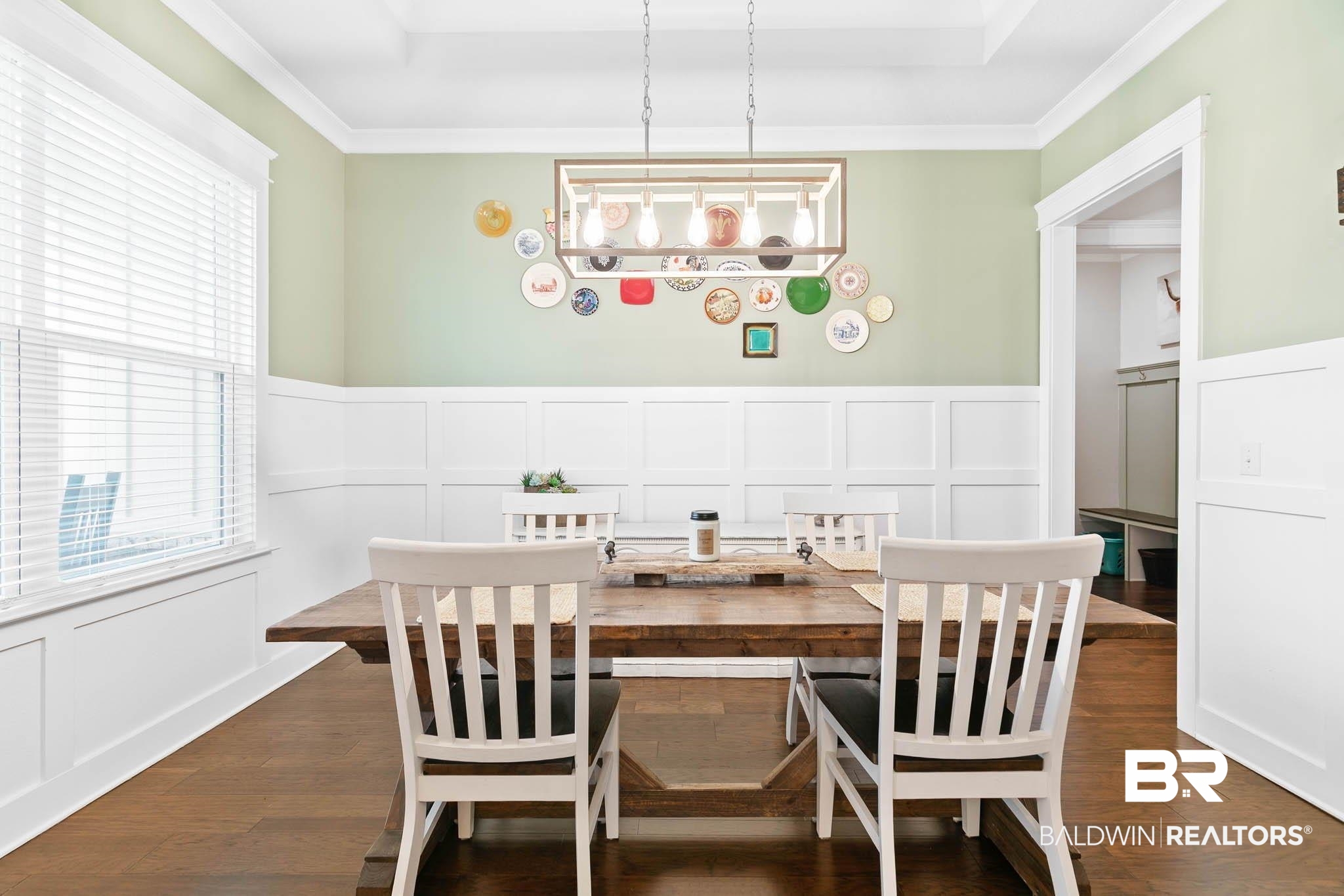 12785 Warbler Street Daphne, AL 36527 - Photo 26 of 53 Dining area featuring a decorative wall, a wainscoted wall, dark wood finished floors, and crown molding