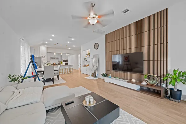 a view of a livingroom with a ceiling fan & wooden floor