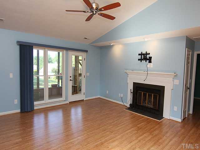 2611 Cottage Circle Raleigh, NC 27613 - Photo 2 of 15 a view of an empty room with wooden floor fireplace and a window
