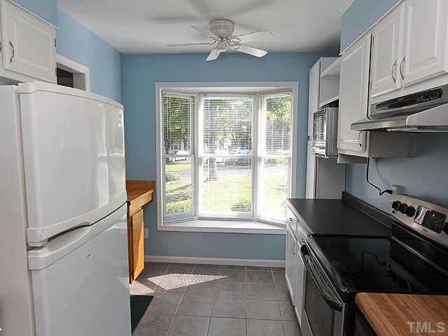 2611 Cottage Circle Raleigh, NC 27613 - Photo 5 of 15 a kitchen with a refrigerator a stove a sink and a window