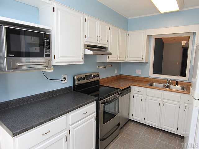 2611 Cottage Circle Raleigh, NC 27613 - Photo 6 of 15 a kitchen with white cabinets a sink and dishwasher