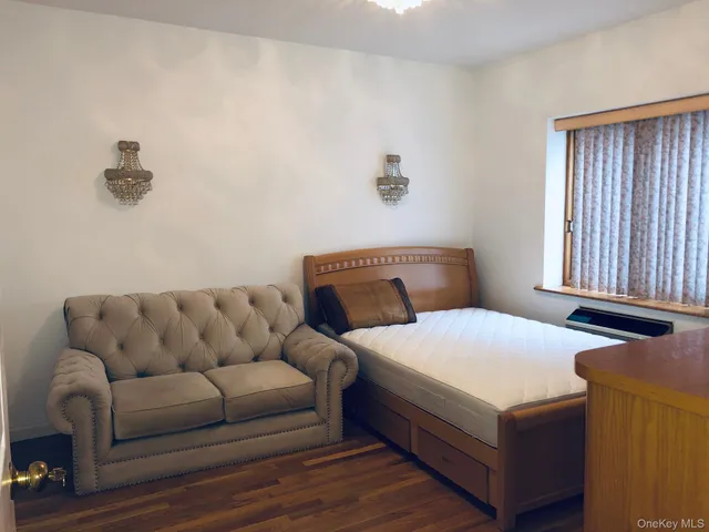 a bedroom with a bed couch and window