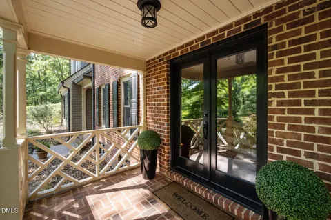 a view of a porch with furniture and floor to ceiling window