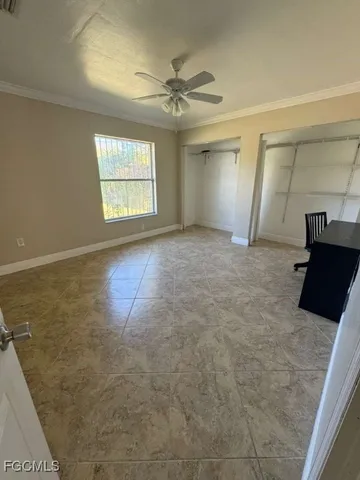 en empty room with windows and a ceiling fan