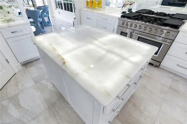 a kitchen with stainless steel appliances granite countertop a stove a sink and a white cabinets