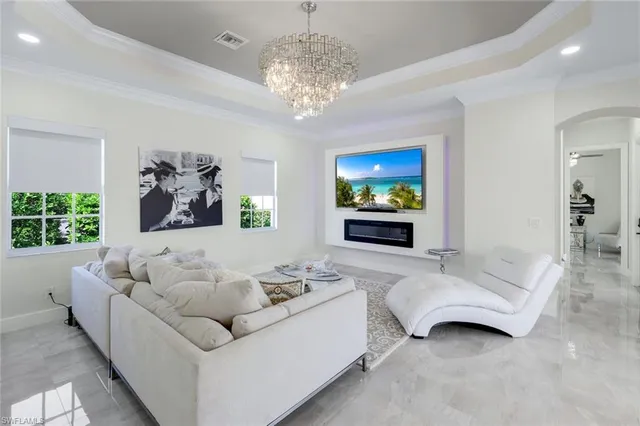 a living room with furniture a flat screen tv and a floor to ceiling window