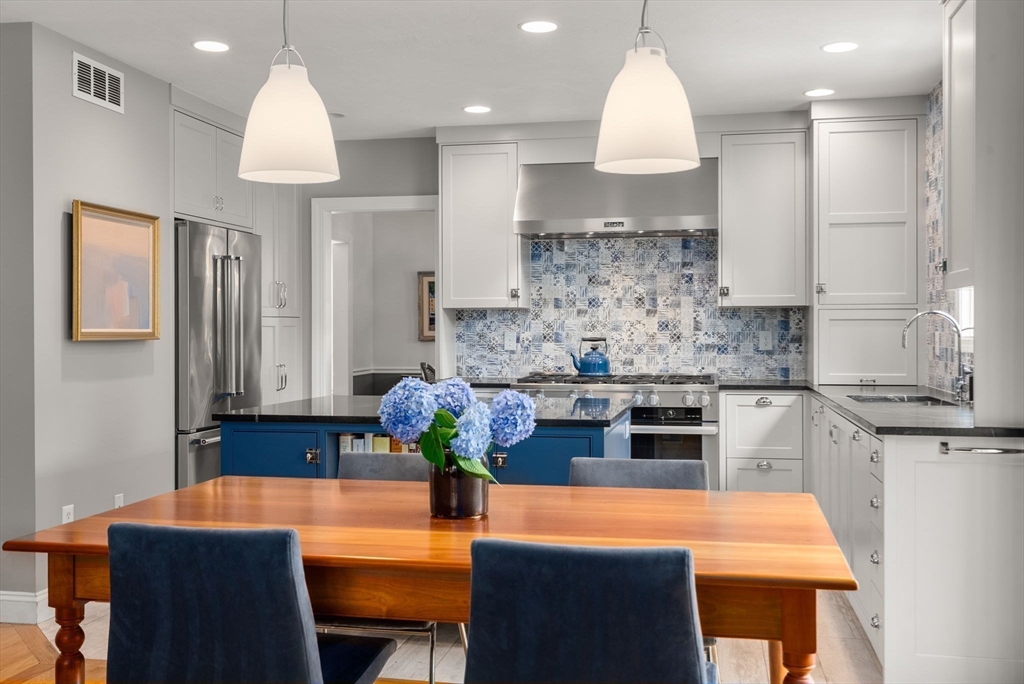 5 Upham Way, Unit 5 Weston, MA 02493 - Photo 5 of 29 a kitchen with kitchen island granite countertop a sink a stove a dining table and chairs