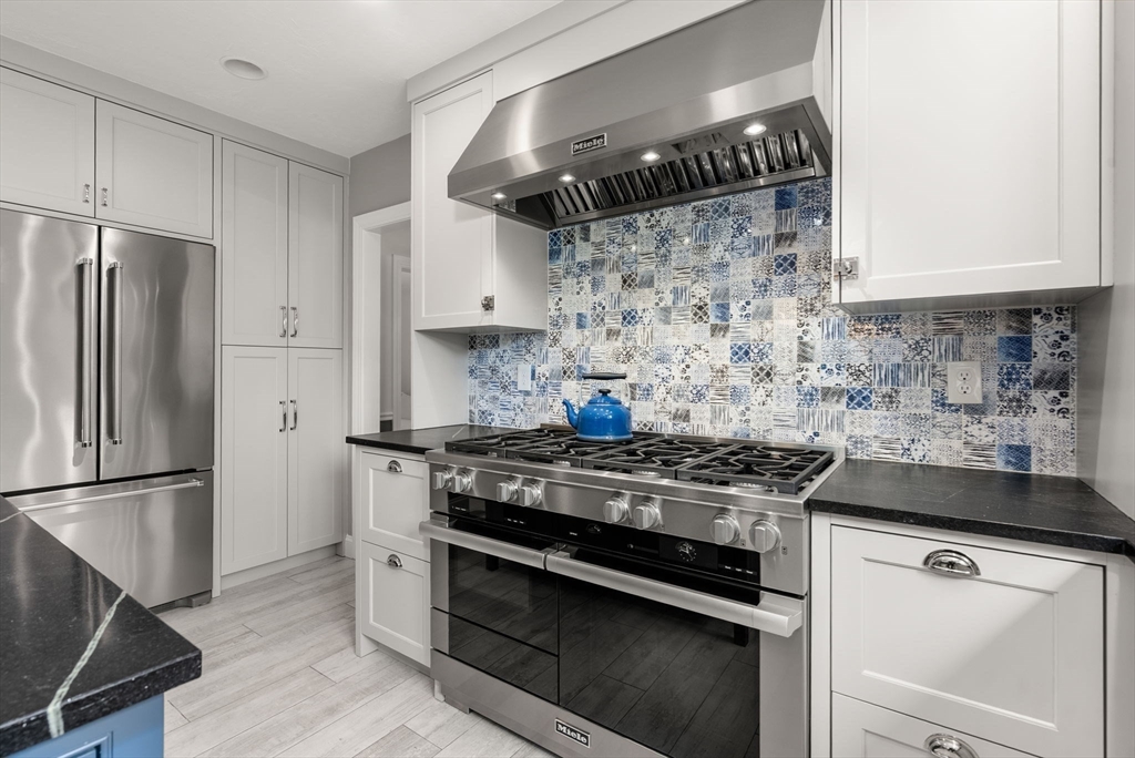 5 Upham Way, Unit 5 Weston, MA 02493 - Photo 8 of 29 a kitchen with granite countertop a stove and a refrigerator