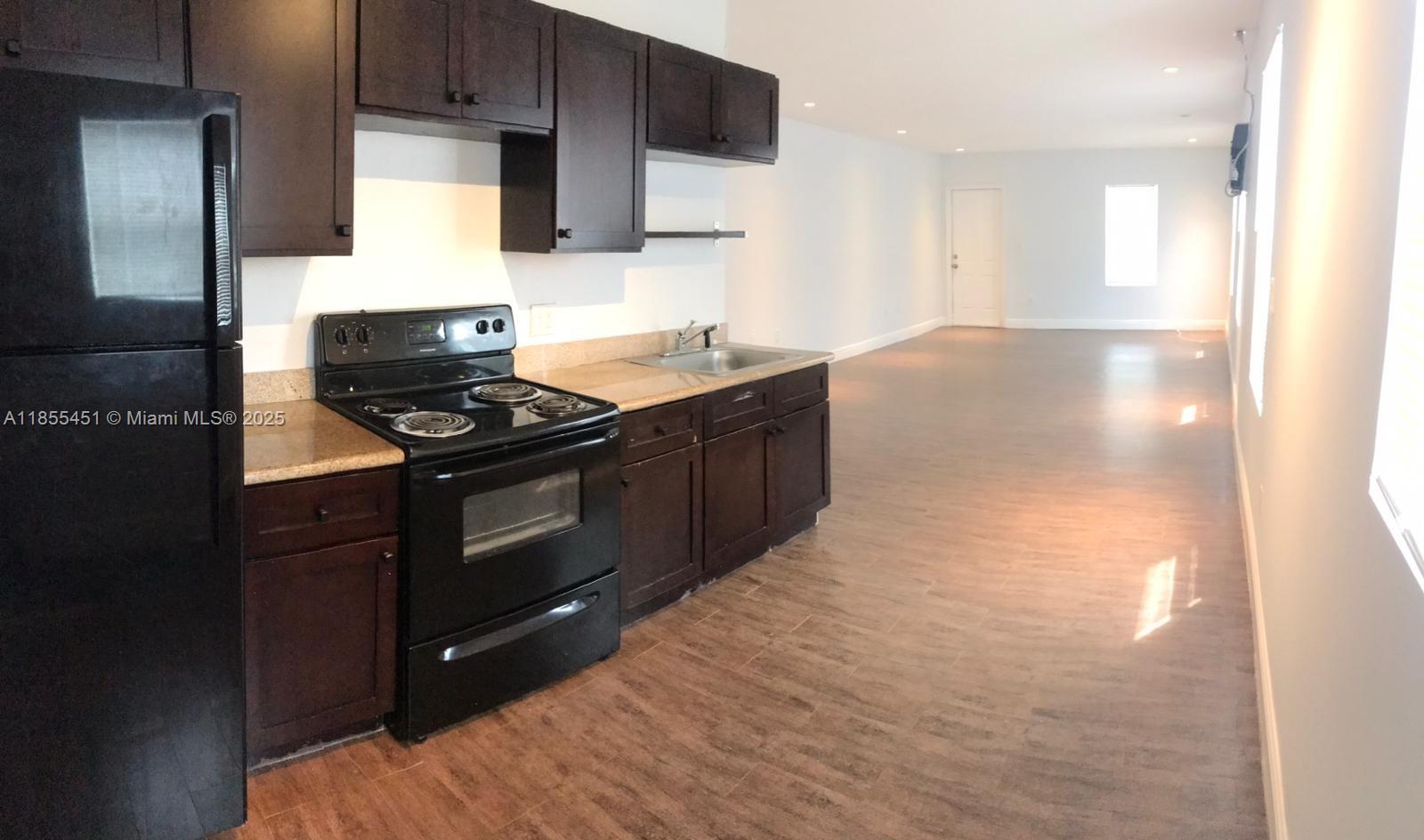 131 Northwest 15th Street, Unit U Miami, FL 33136 - Photo 2 of 6 a kitchen with stainless steel appliances a stove a sink and a microwave