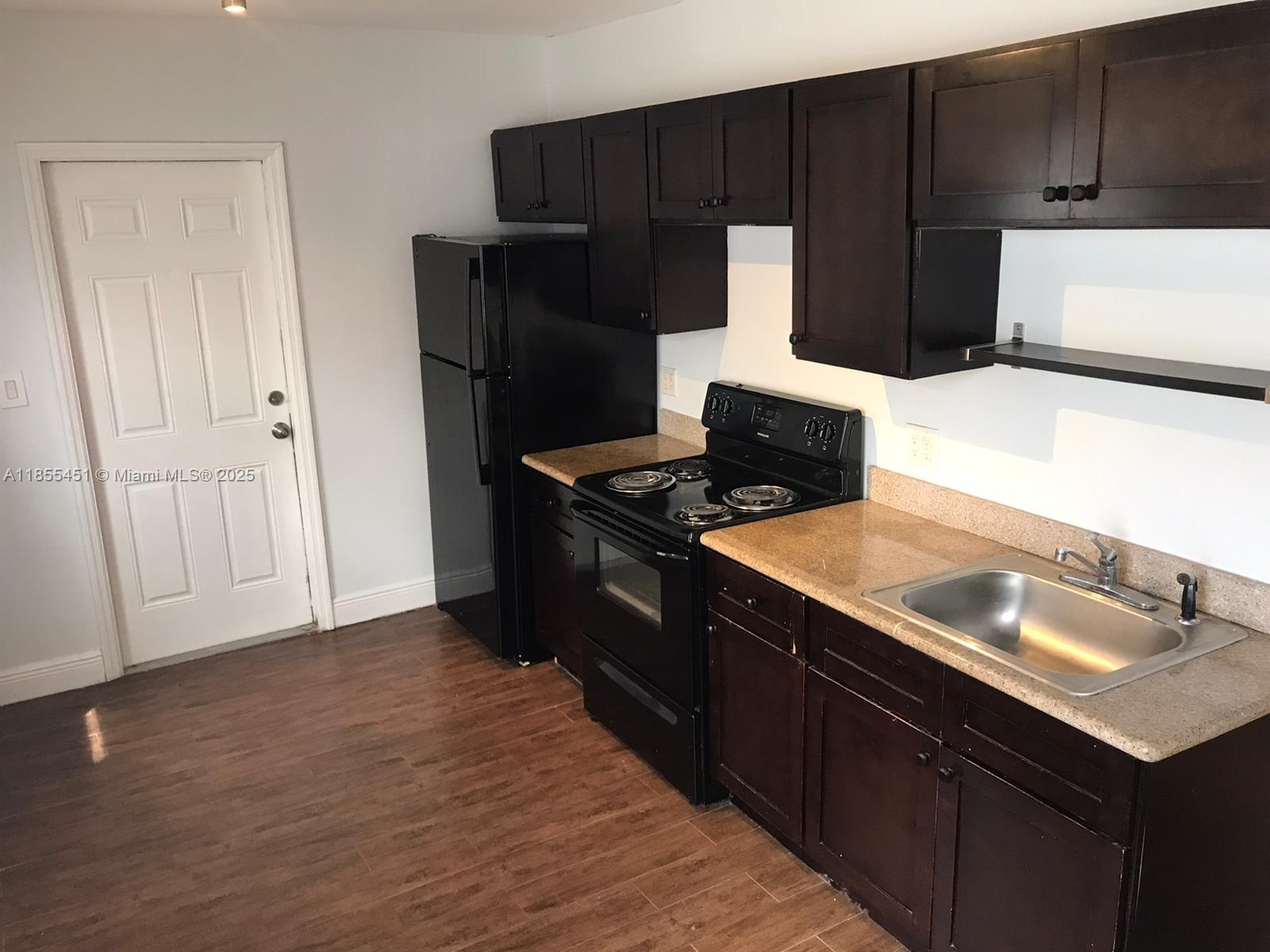 131 Northwest 15th Street, Unit U Miami, FL 33136 - Photo 5 of 6 a kitchen with a sink and a refrigerator