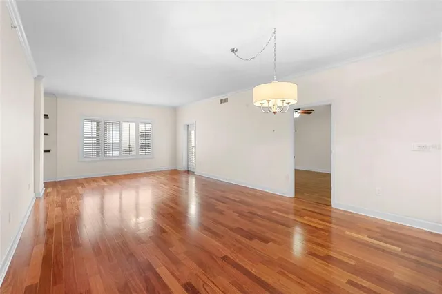 a view of a room with wooden floor and chandelier