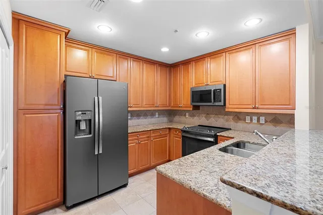 a kitchen with stainless steel appliances granite countertop refrigerator sink and microwave