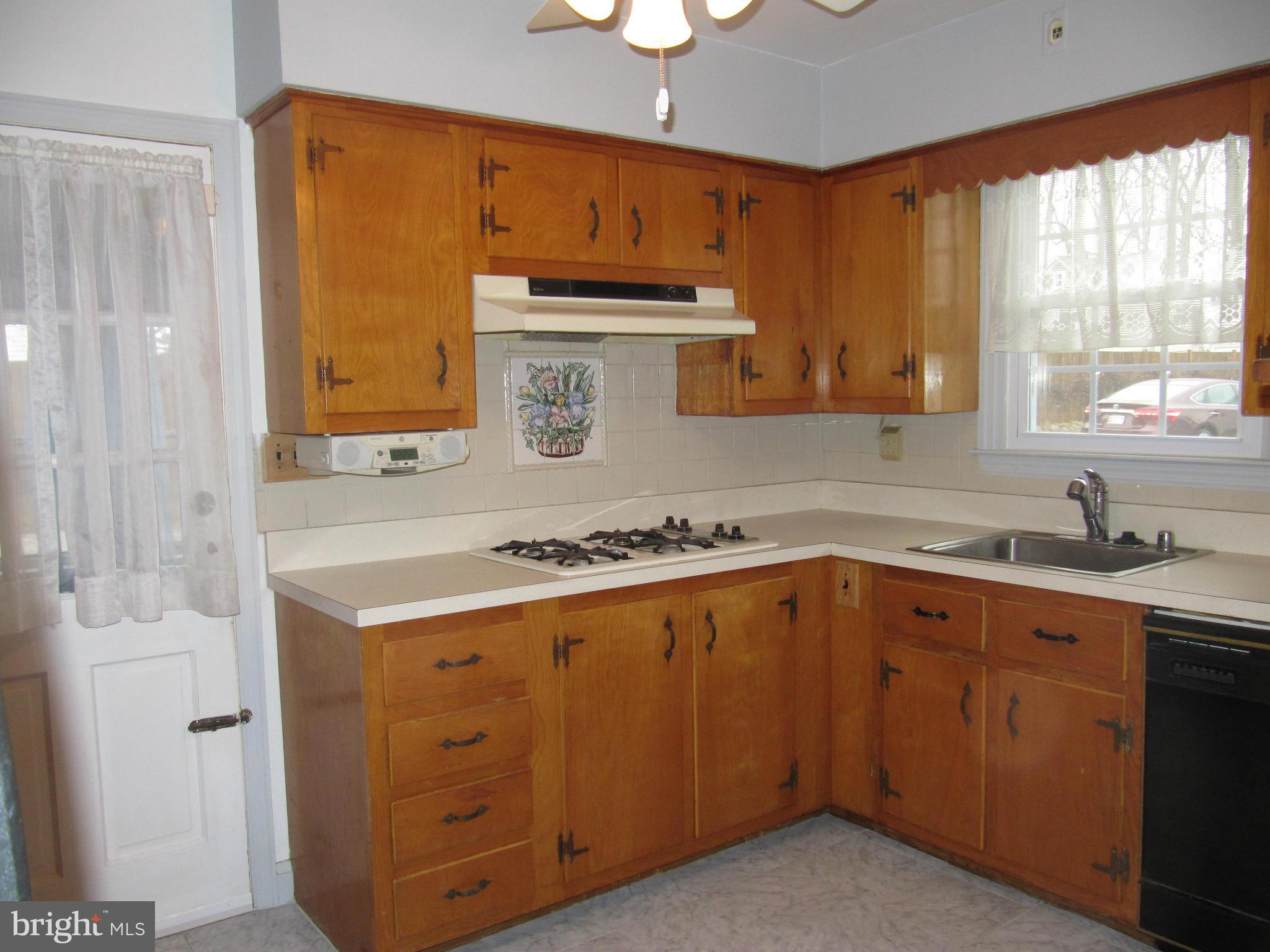 7518 Windsor Mill Road Baltimore, MD 21244 - Photo 4 of 17 a kitchen with a sink stove and cabinets