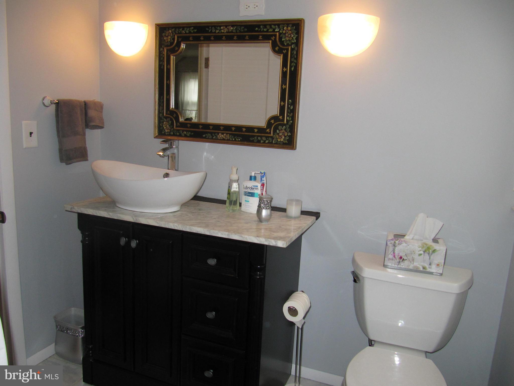 7518 Windsor Mill Road Baltimore, MD 21244 - Photo 8 of 17 a bathroom with a toilet sink and mirror