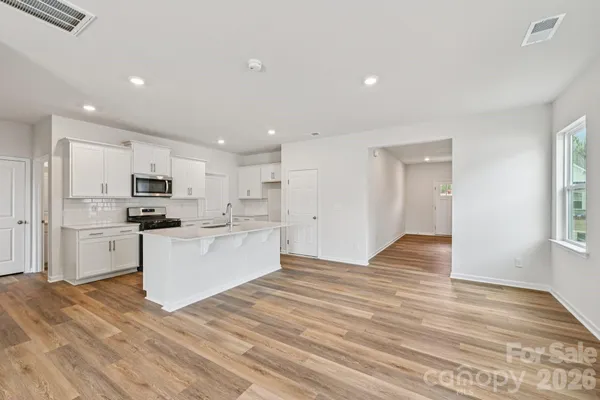 a view of kitchen with granite countertop cabinets and refrigerator