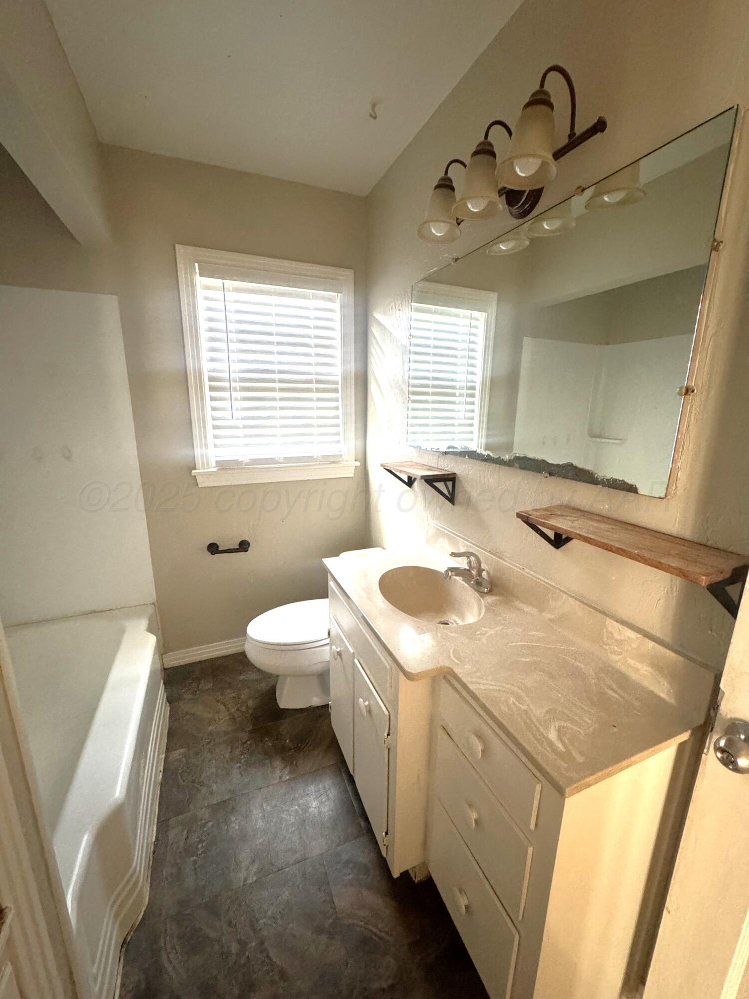 1222 South Bryan Street Amarillo, TX 79102 - Photo 15 of 18 a bathroom with a granite countertop sink mirror vanity and toilet