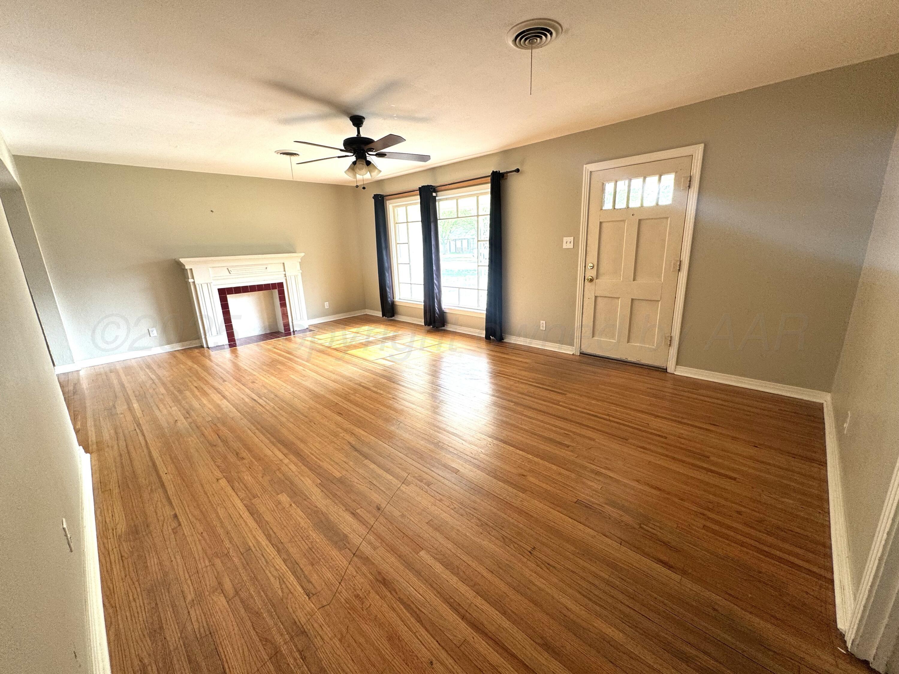 1222 South Bryan Street Amarillo, TX 79102 - Photo 3 of 18 a view of a livingroom with wooden floor and a ceiling fan