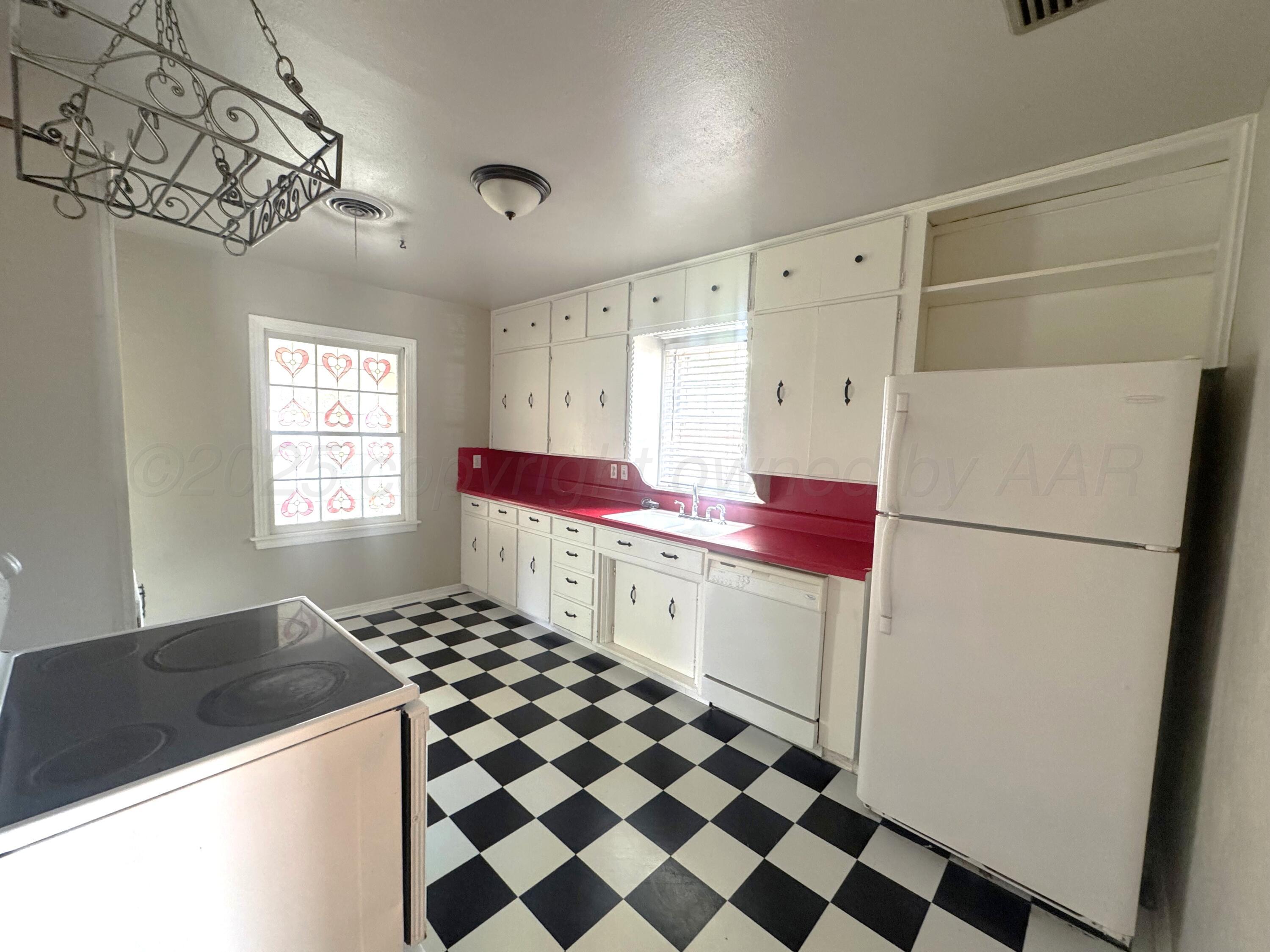 1222 South Bryan Street Amarillo, TX 79102 - Photo 7 of 18 a kitchen with a refrigerator and a stove top oven
