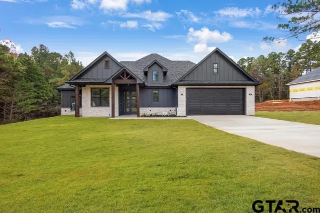 a front view of a house with yard and green space