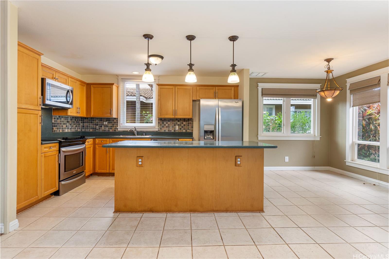 92-247 Opuakii Place Kapolei, HI 96707 - Photo 9 of 25 a kitchen with stainless steel appliances granite countertop a stove a sink and a refrigerator