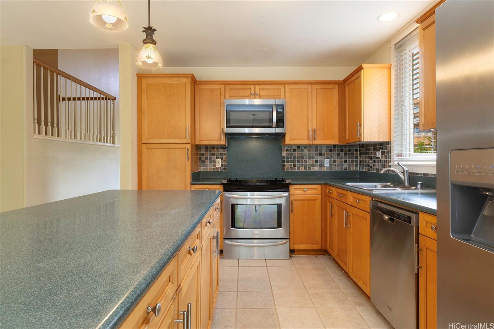 92-247 Opuakii Place Kapolei, HI 96707 - Photo 10 of 25 a kitchen with stainless steel appliances granite countertop a sink a stove and a refrigerator