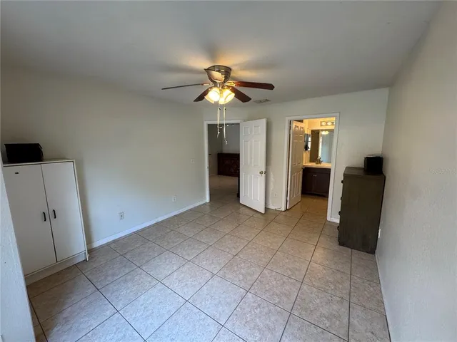 an empty room with closet and a chandelier fan