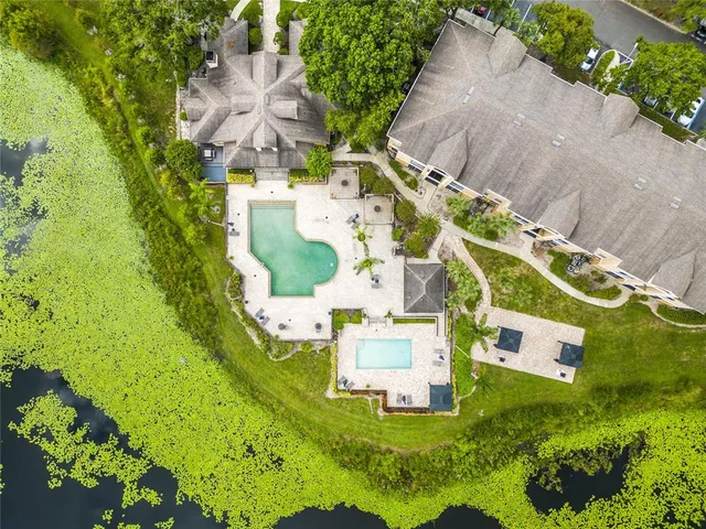 an aerial view of residential house with outdoor space and trees all around