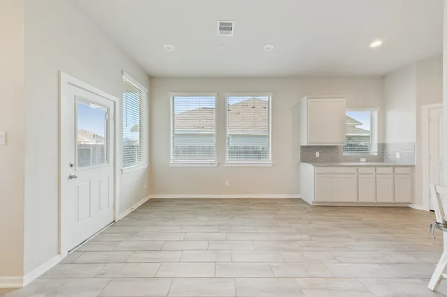 a view of kitchen with granite countertop cabinets and window