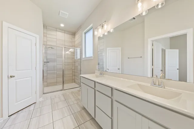 a bathroom with a shower sink and mirror