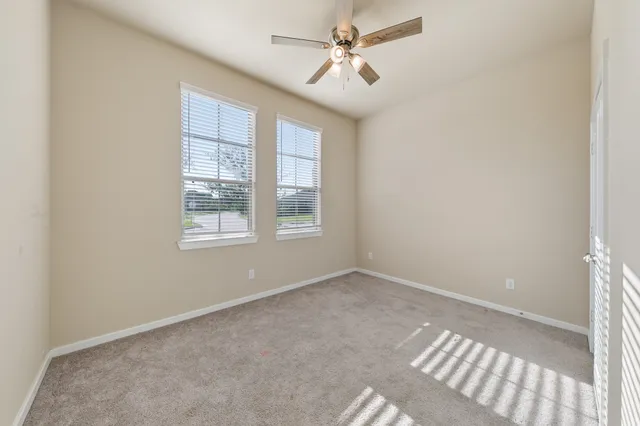 an empty room with chandelier fan
