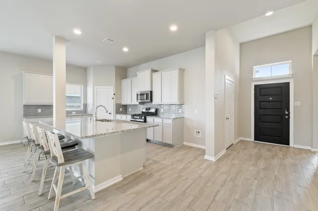 a kitchen with white cabinets and stainless steel appliances