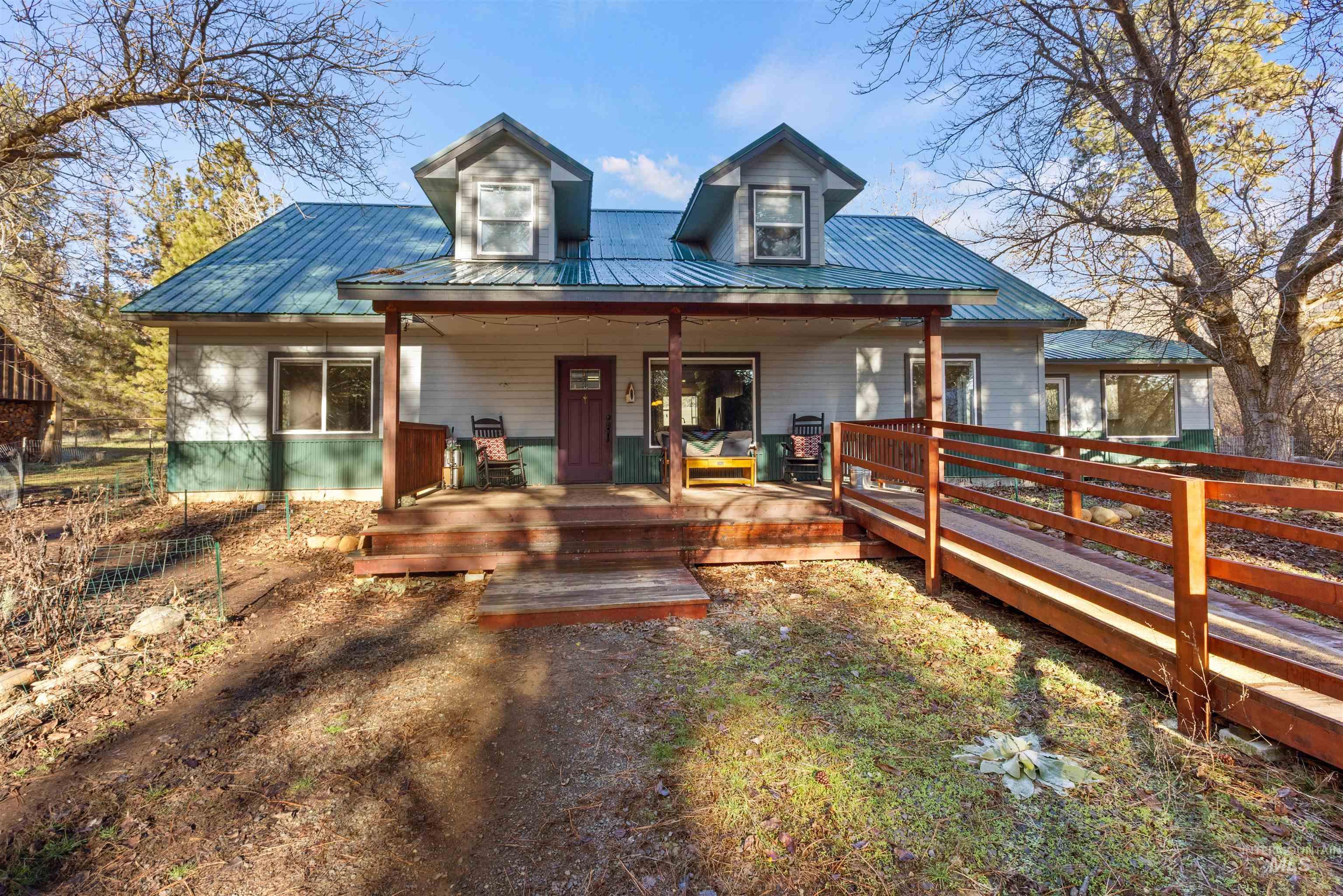 View of front of house featuring a metal roof and covered porch