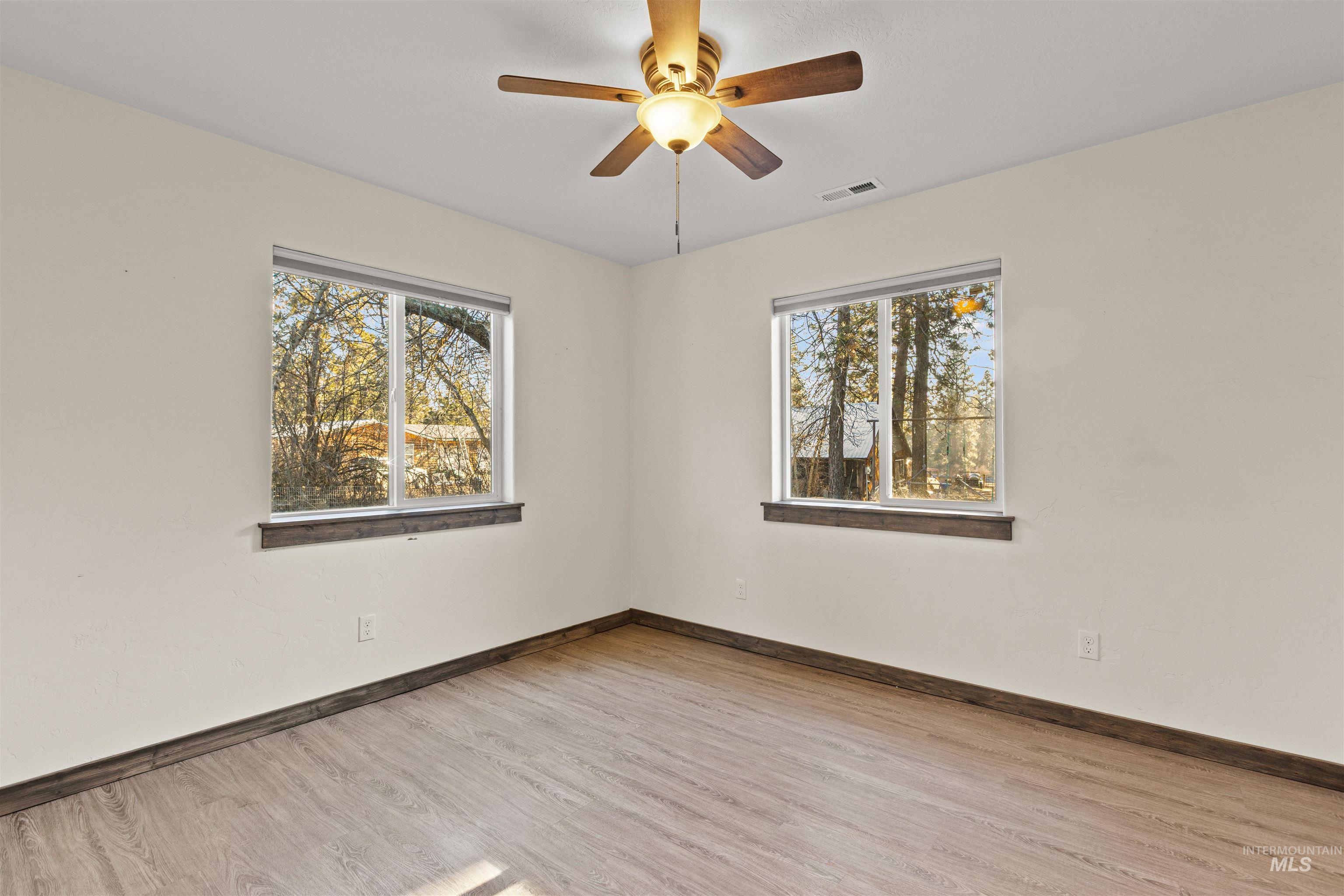 3488 Ward Road Cambridge, ID 83610 - Photo 28 of 49 Empty room with healthy amount of natural light, light wood finished floors, and a ceiling fan