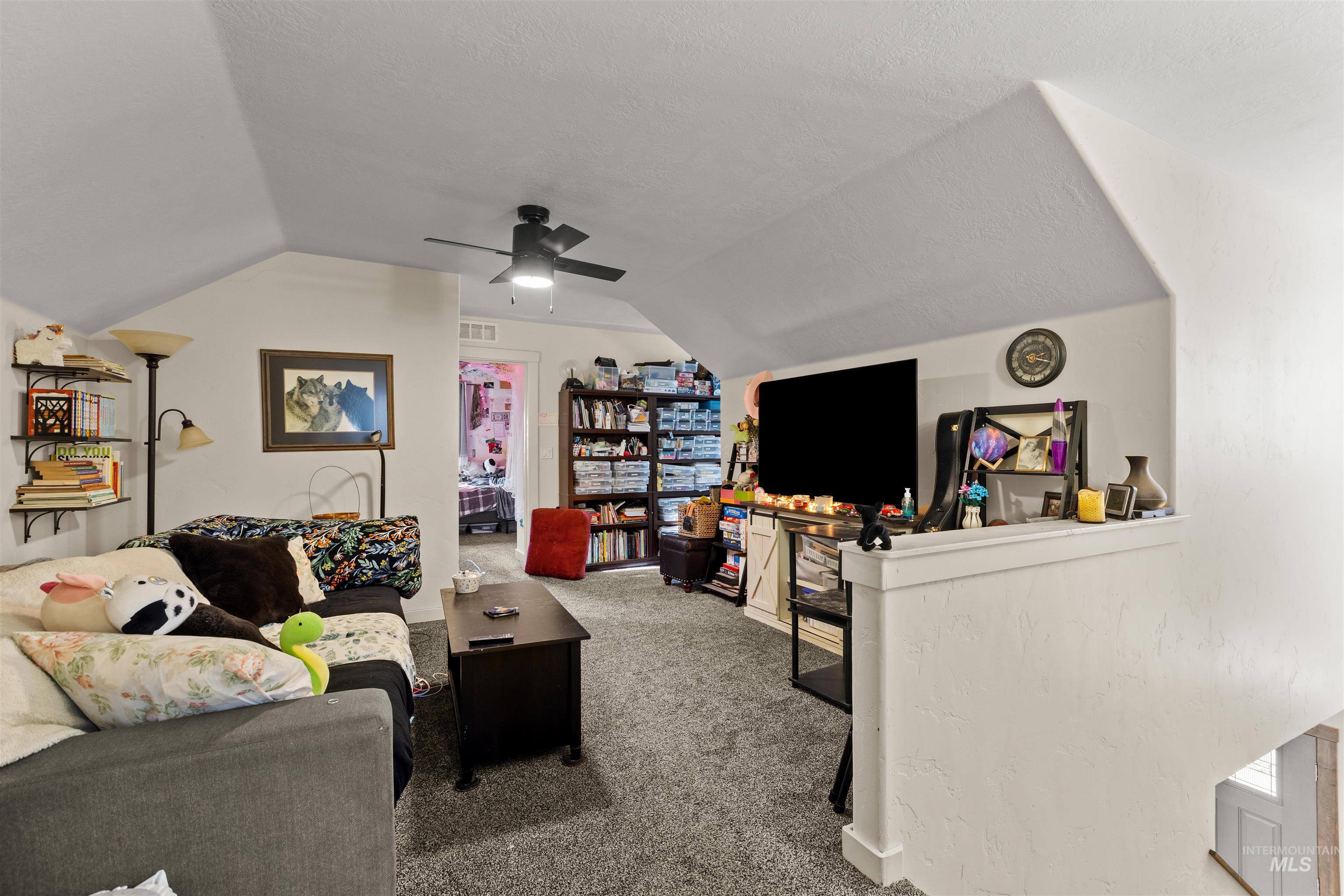 3488 Ward Road Cambridge, ID 83610 - Photo 30 of 49 Carpeted landing area featuring vaulted ceiling, a ceiling fan, and a textured ceiling
