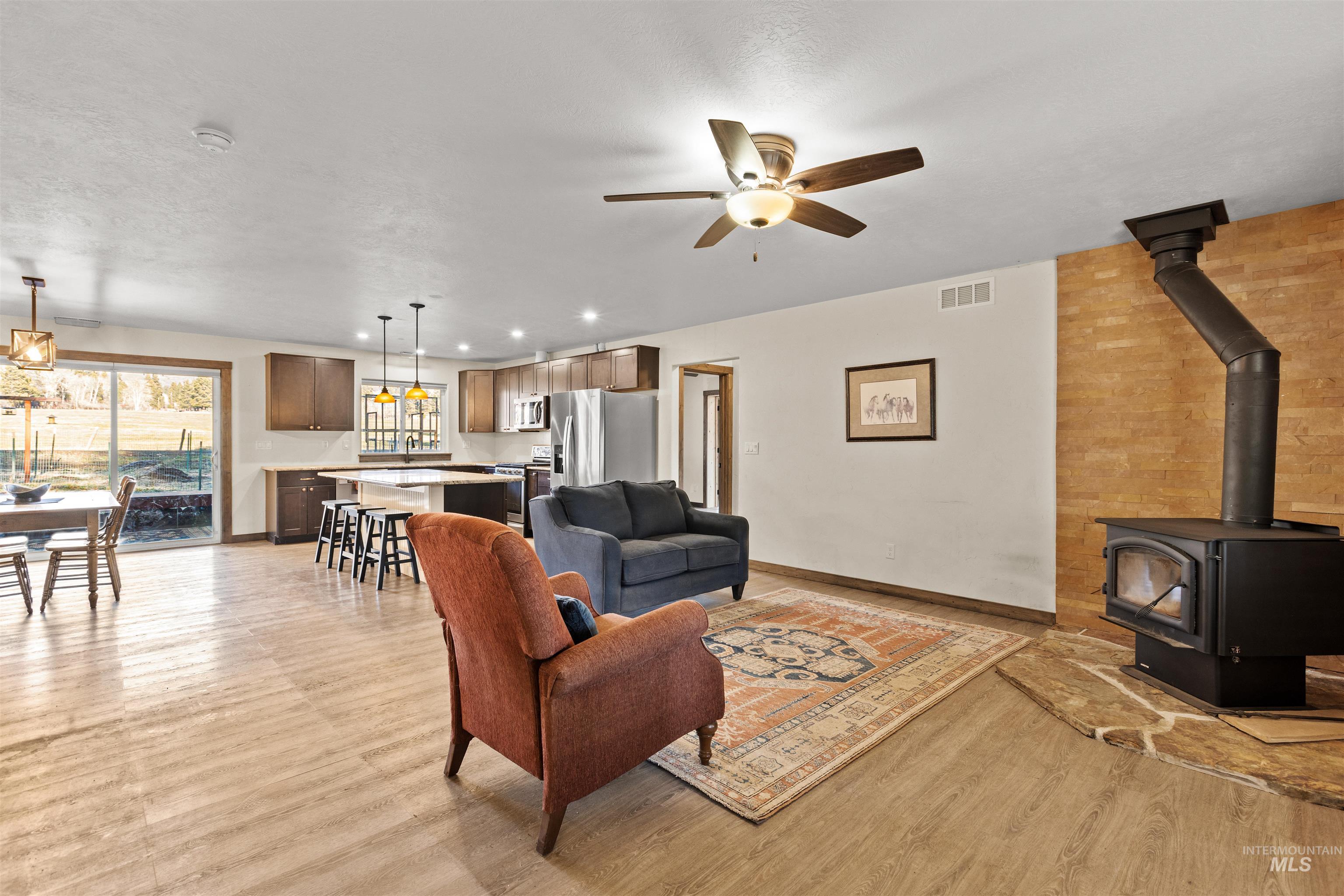 3488 Ward Road Cambridge, ID 83610 - Photo 3 of 49 Living room featuring a wood stove, light wood finished floors, ceiling fan, and recessed lighting