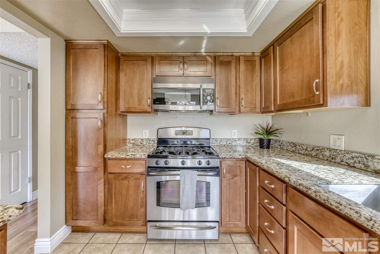 6282 Chesterfield Lane Reno, NV 89523 - Photo 12 of 34 a kitchen with granite countertop a stove sink and cabinets