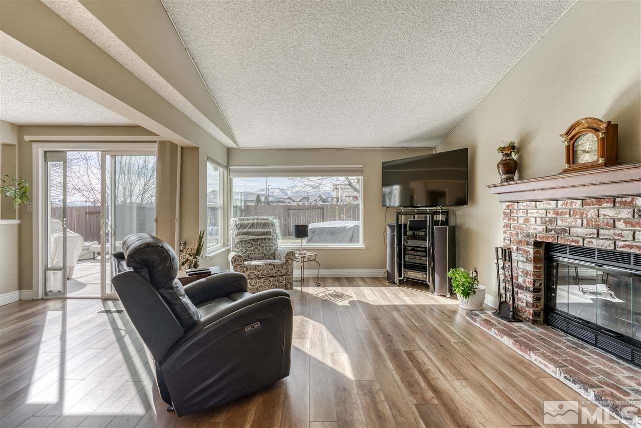 6282 Chesterfield Lane Reno, NV 89523 - Photo 5 of 34 a living room with furniture a fireplace and a floor to ceiling window