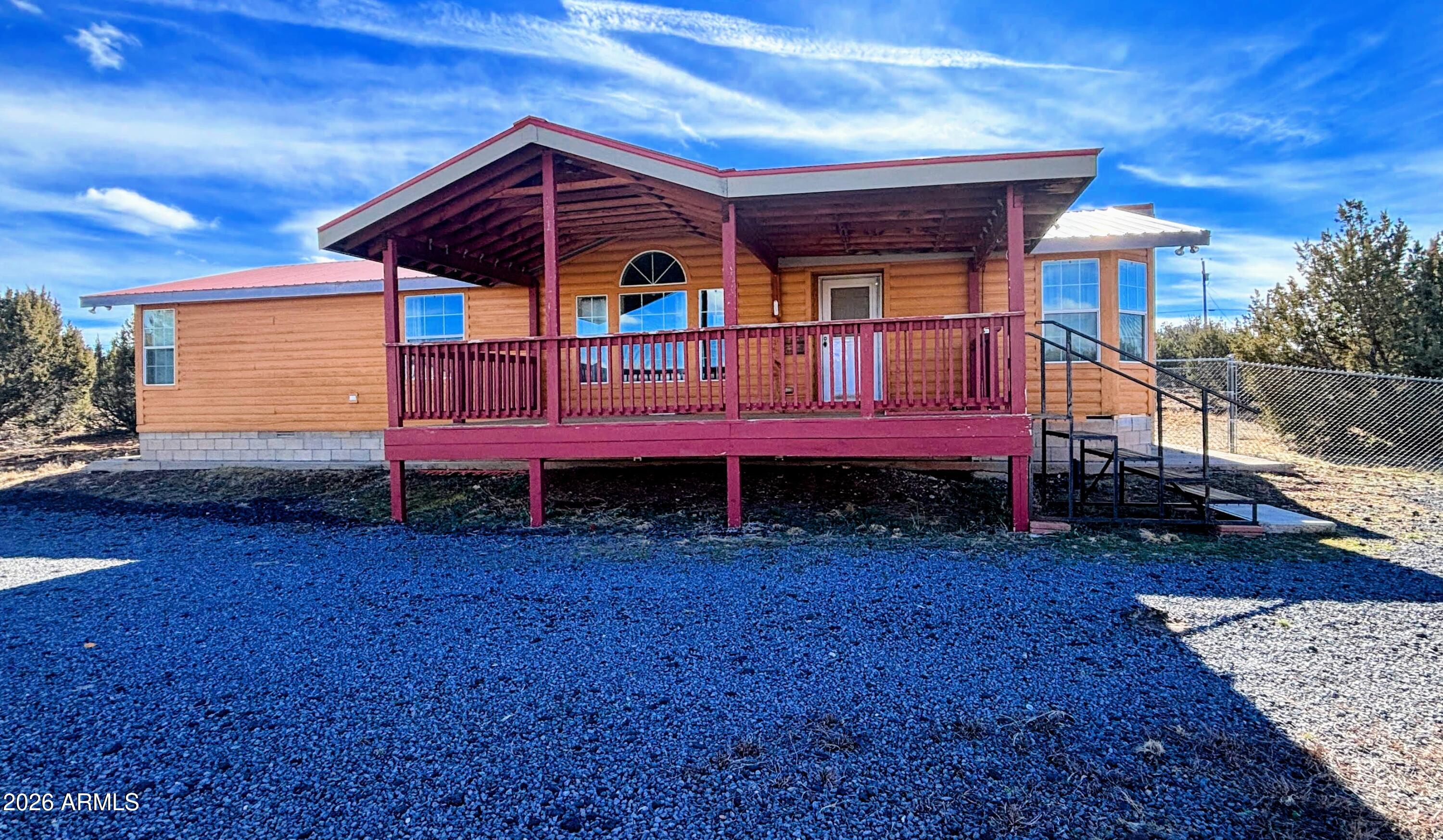 a view of a backyard with a deck and furniture