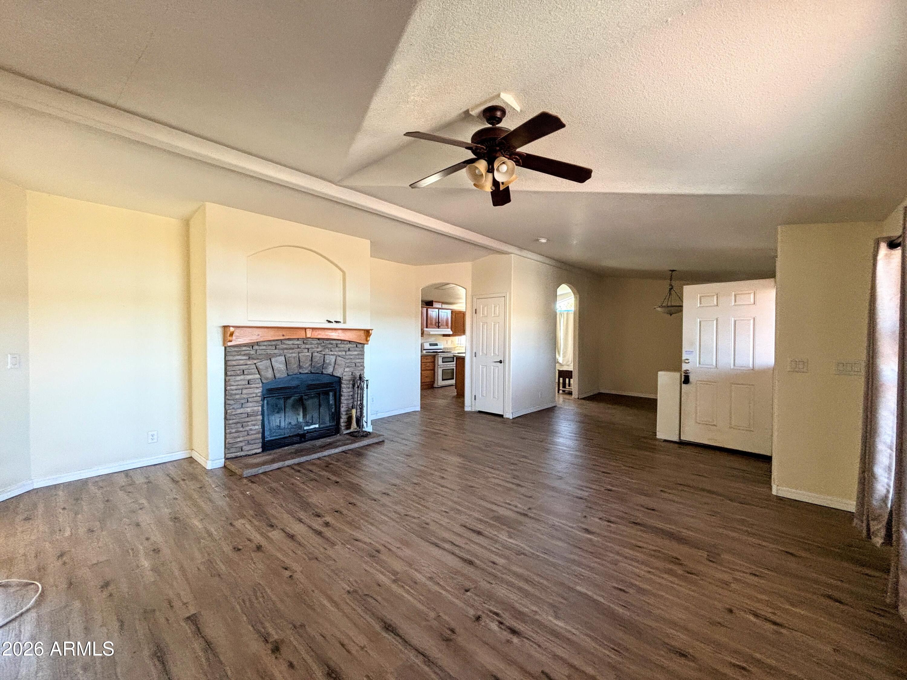 111 County Road, Unit 8015 Show Low, AZ 85901 - Photo 3 of 34 a view of empty room with wooden floor and fireplace