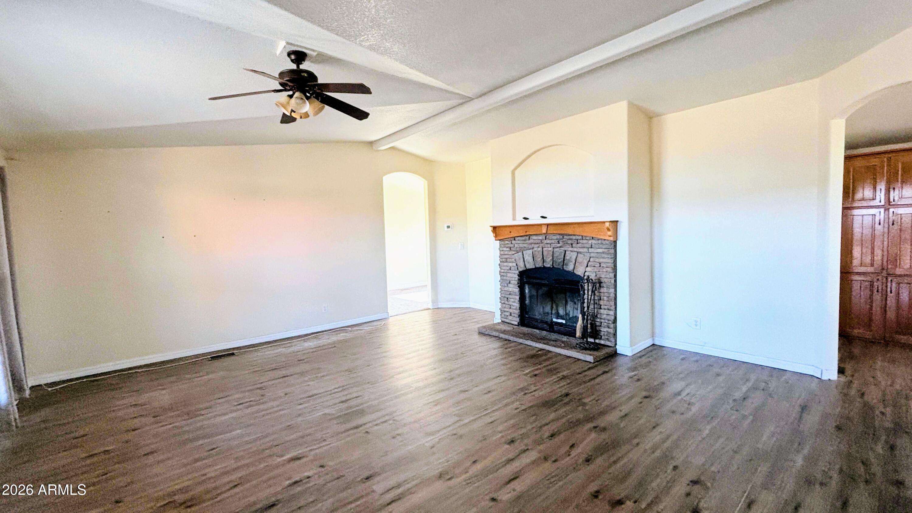 111 County Road, Unit 8015 Show Low, AZ 85901 - Photo 7 of 34 a view of an empty room with wooden floor a fireplace and a window
